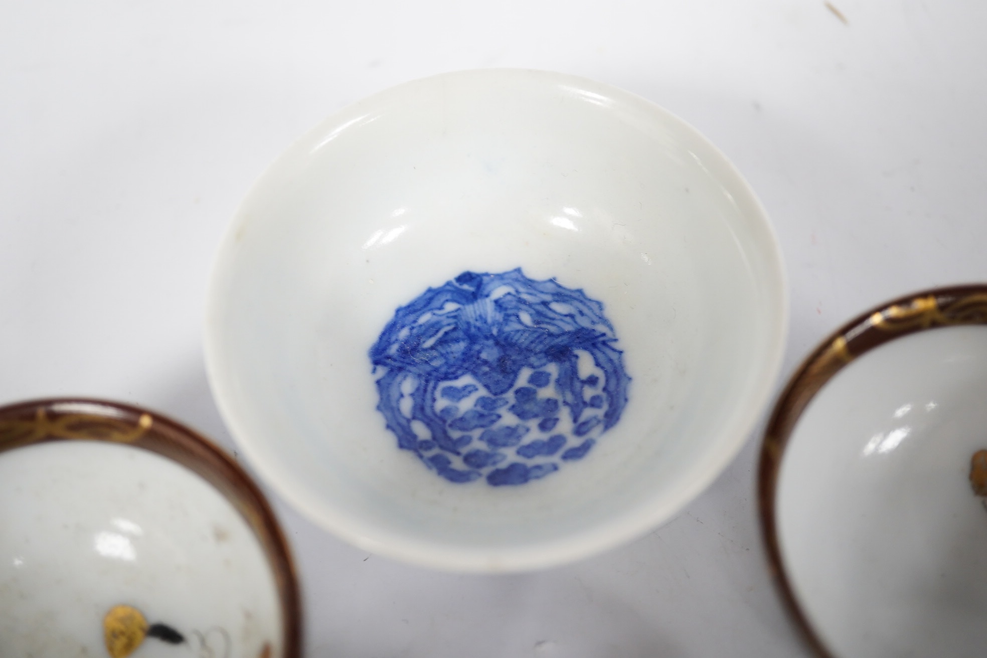 Six Japanese sake bowls, two pairs and two single, tallest 4cm. Condition - some chips